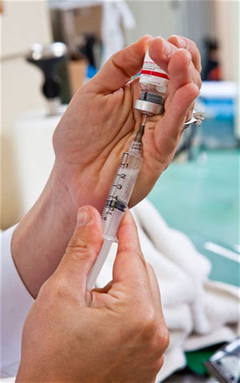 2 vaccines approved for use in singapore. Person filling syringe with vaccine