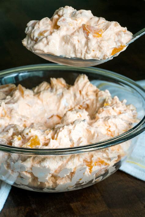 1 (8 oz.) package cream cheese, room temperature 1 cup powdered sugar 1 (12 oz.) container frozen whipped topping 1 (3 oz.) package peach or orange jello 2 (14 oz.) cans sliced peaches in syrup, chopped (drained, but with 2 tablespoons reserved) 1 (8 oz.) container small curd cottage cheese Millionaire Peach Salad | 12 Tomatoes