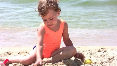 Between the combination of the anatomy and absolutely wonderful conditions, the shape is supposed to look like the looking for more camel toe? Little girl play with sand on beach - Royalty Free Video