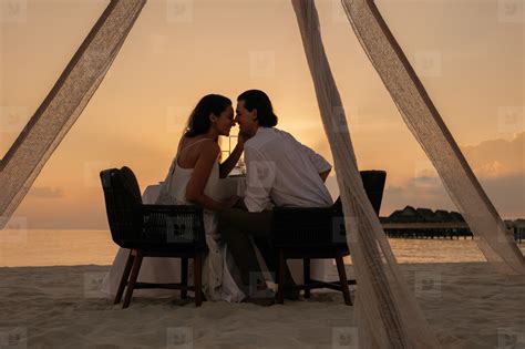 Photos - Romantic couple kissing at sunset dinner 213839 - YouWorkForThem
