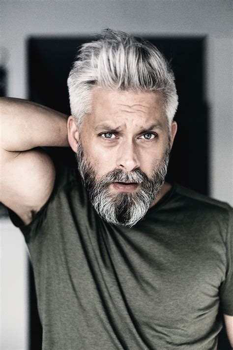 Surprised grey haired man looking at camera isolated on grey, banner. Model swedish grey hair silverfox mens style beard ...