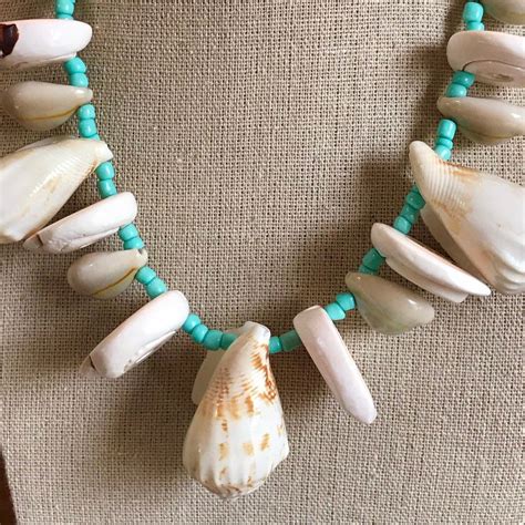 After the submarine is summoned. Cone shell, cowrie, and strawberry conch seashell necklace ...