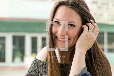 Tucking hair behind ear emoji. A woman tucking her hair behind her ear — Photo — Lightstock