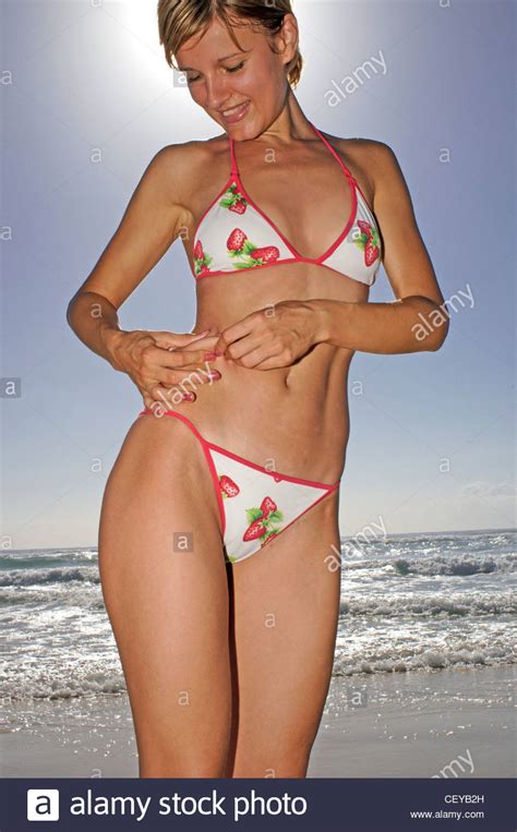Beach waves are textured, tousled, loose curls (similar to when you've been at the beach, hence the name). Female, short blonde hair, white bikini with red edging ...