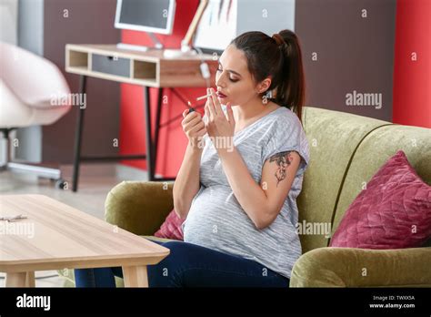 Pregnant woman smoking at home Stock Photo - Alamy