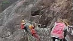 Professional worker installing wire mesh fence protection slope prevent landslide