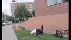 Guy doing bmx trick off building faceplants into the grass fail