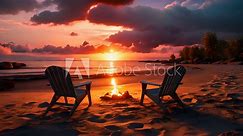 Two empty lounge chairs side by side in front of a bonfire at sandy beach during tropical sunset