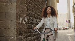 Latina girl in casual attire biking through the Gothic Quarter of Barcelona - mobility and sustainability concept