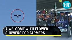 Watch: Aircraft showers flower petals as farmers return home after ending protests