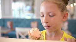 Cute Girl eats Ice cream Cone, licks it with Tongue
