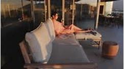 Serene, barefoot woman in pink dress relaxing on luxury sunset patio...