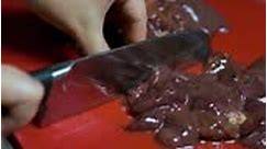 Female hands cutting raw chicken rabbit turkey goose duck liver on a...