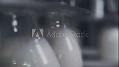 Close Up. Milk Production Plant. Glass Bottle is Being Filled With Milk. Multiple Bottles are Attached to the Rotating Part of the Machine. Spinning Motion. Industrial Production Process.Conveyor Line