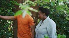 African american senior couple holding hands walking together in the garden