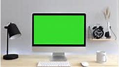 Computer desktop with mock-up green screen on wood table with grey...