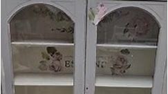 Shabby chic / Cottage style china cabinet/bookcase adorned with French flowers. Very sweet for any room. Light gray exterior and white interior $395 | The Garage & The Garage Girls - Antiques, Suffern, NY