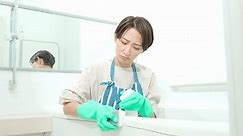 Japanese woman cleaning the bath with a troubled face